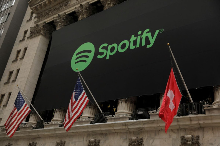 The Spotify logo hangs on the facade of the New York Stock Exchange with U.S. and a Swiss flag as the company lists its stock with a direct listing in New York, U.S., April 3, 2018.  