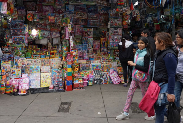 People walk past a stand that sells toys and other products imported from China at Central Market in Lima, Peru August 9, 2018.  