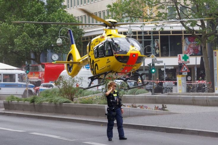 A police officer walks as a first-response helicopter takes off at the scene where a car crashed into a group of people near Breitscheidplatz in Berlin, Germany, June 8, 2022.