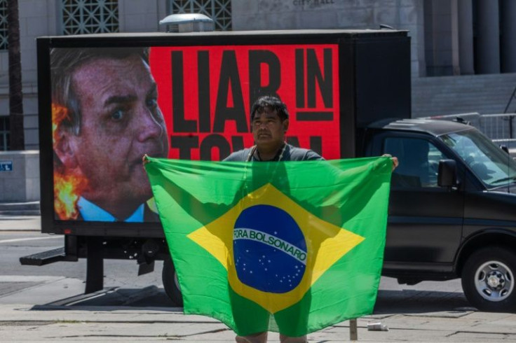 Toya Elcio Manchineri holds a Brazilian flag during a protest against Brazil's President Jair Bolsonaro, calling on global leaders to protect the rainforest, in Los Angeles amid the Summit of the Americas