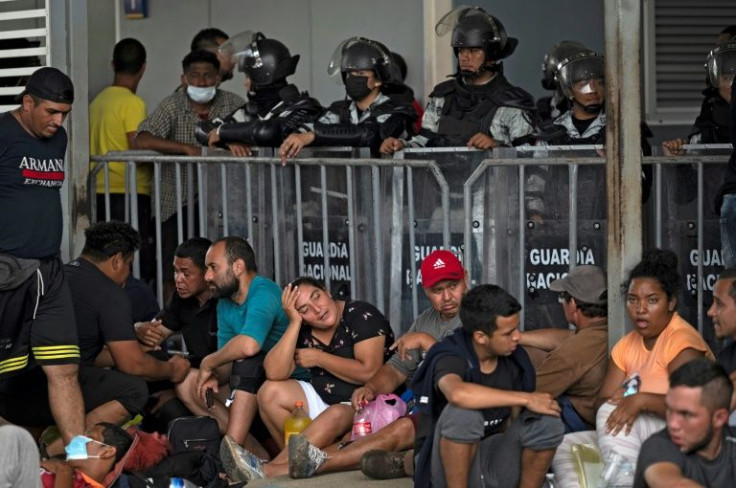 Migrants taking part in a caravan heading to the United States, wait for transit visas outside an immigration office in Huixtla, Mexico, on June 8, 2022