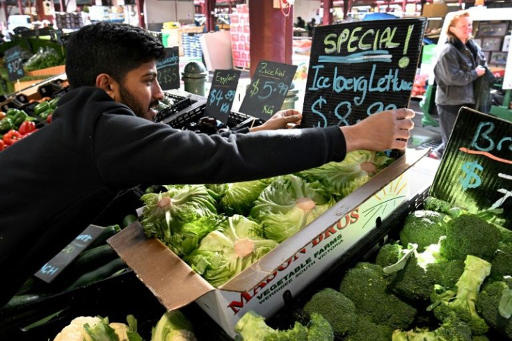Syed Hyder from a stall at Melbourne's Queen Victoria Market adjusts a display of iceberg lettuce on June 7, 2022, with the local price soaring by as much as 300 percent in recent months.