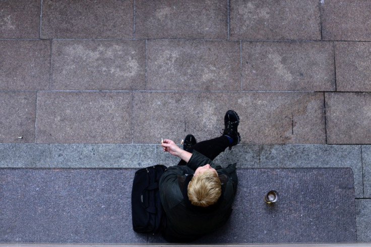A person smokes a cigarette in Canary Wharf in London, Britain May 10, 2017.