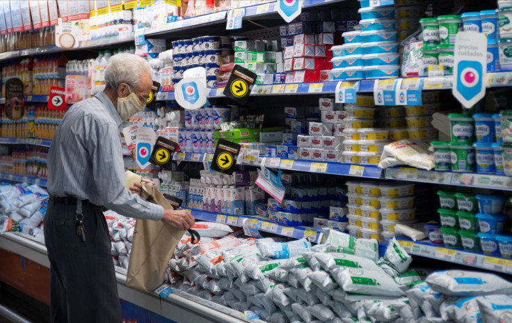 A man stands next to dairy products in a supermarket in downtown Buenos Aires, Argentina November 8, 2021.