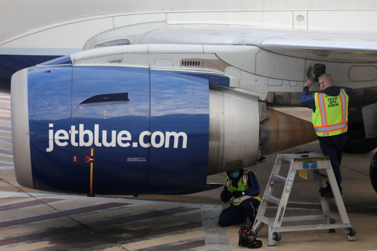 Technicians inspect a JetBlue Embraer 190 aircraft at Ronald Reagan Washington National Airport in Arlington, Virginia, U.S. December 7, 2021.