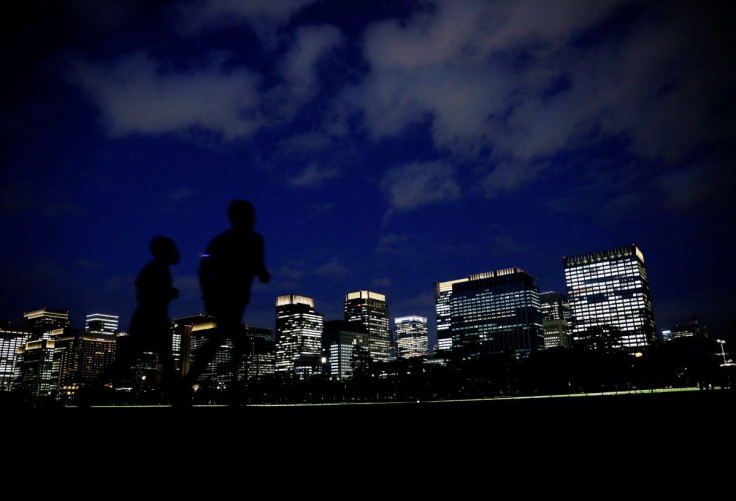 People run with Tokyo's business district in the background, in Tokyo, Japan, April 7, 2021. Picture taken April 7, 2021. 