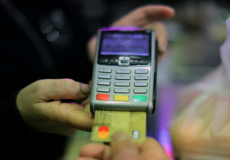 A shopper uses a  credit card to pay for goods in a grocery in Nice, France, April 3, 2019.  