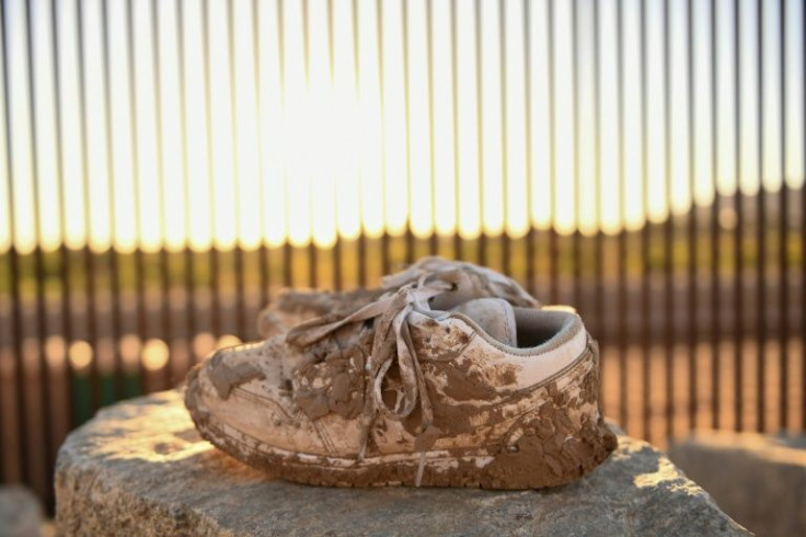 A pair of mud-crusted shoes rests near a gap along the border wall between the US and Mexico in Yuma, Arizona on May 31, 2022