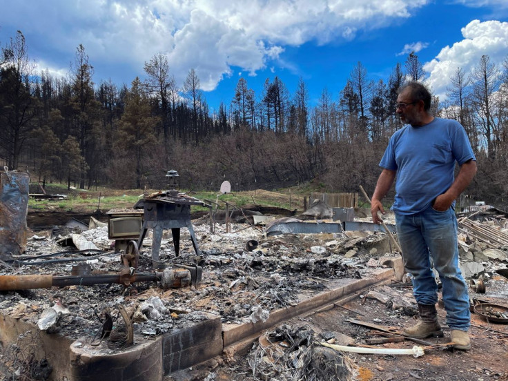 Daniel Encinias stands next to the ruins of his home destroyed by the Hermits Peak Calf Canyon fire in Tierra Monte, New Mexico, U.S., June 9, 2022. Picture taken June 9, 2022.