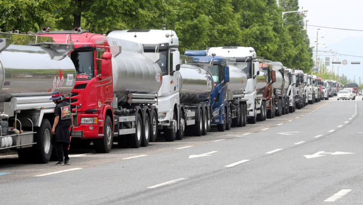 A member of the Cargo Truckers Solidarity union stands next to a truck during a strike in Yeosu, South Korea, June 9, 2022. Yonhap via