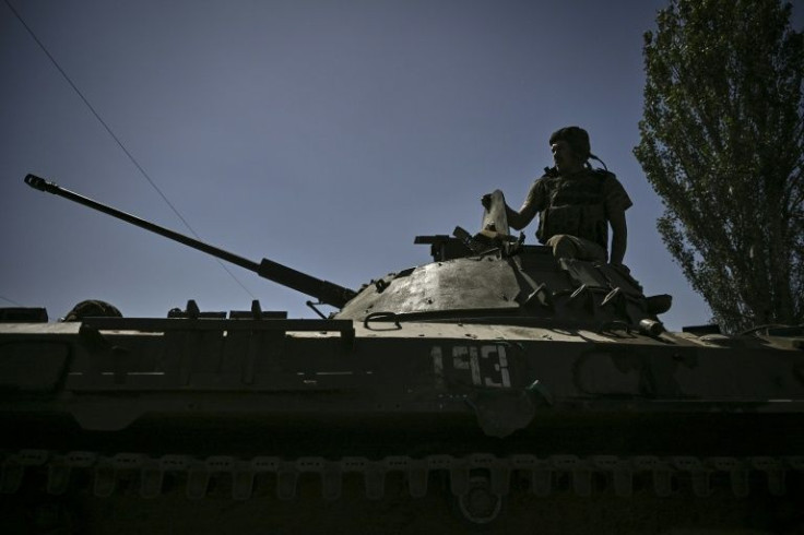 A Ukrainian soldier sits on an armoured vehicle moving towards the front line in the city of Lysychansk