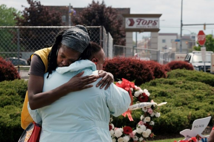 People embrace near a memorial for the victims of a shooting at a supermarket in Buffalo, New York