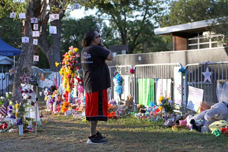 Rudy Ayala, of El Paso, visits the memorial for the shooting victims outside Robb Elementary School early Saturday morning in Uvalde, Texas, U.S., June 11, 2022.   
