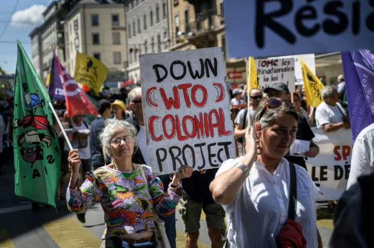 A demonstrator holds a 'Down (WTO) Colonial Project' placard in a rally against the World Trade Organization in Geneva