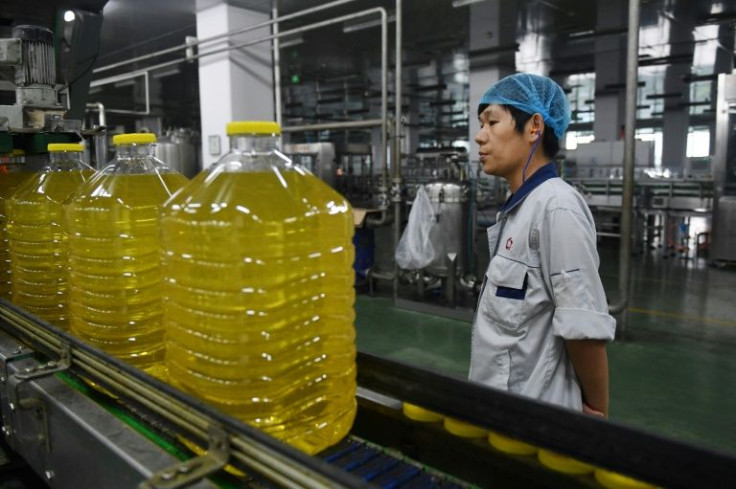 A worker at the Hopeful Grain and Oil Group factory in Sanhe, China monitors oil from soybeans imported from Brazil in 2018