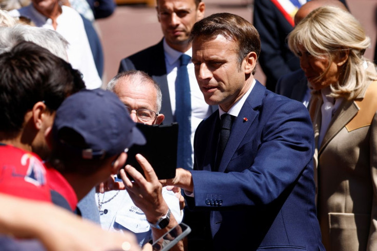 French President Emmanuel Macron and his wife Brigitte Macron greet people as they arrive to vote in the first round of French parliamentary elections, at a polling station in Le Touquet-Paris-Plage, France, June 12, 2022.