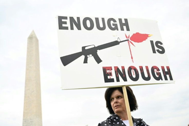 A protester holds a sign in Washington, DC on June 11, 2022 during a protest calling for action on gun violence in AmericaFILES) In this file photo taken on June 11, 2022 gun control advocates participate in the "March for Our Lives" as they protest aga