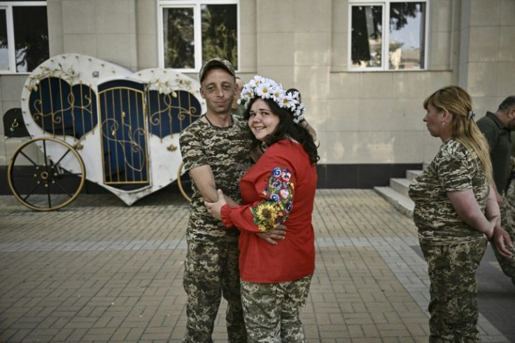 Khrystyna Lyuta wore camouflage trousers and army boots with a traditional red Ukrainian blouse embroidered with flowers to marry her husband Volodymyr Mykhalchuk, 28