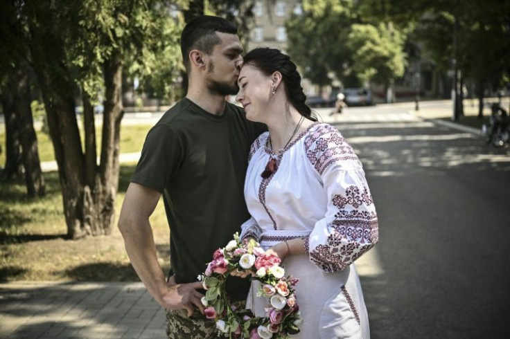 Kristina, 23, opted for a traditional long white dress with red folk embroidery to marry Vitaliy Orlich, also 23, a sniper