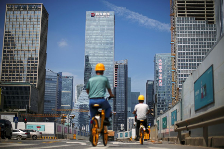Men ride bicycles past construction sites  in Shenzhen, Guangdong province, China September 26, 2021. 