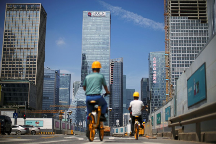 Men ride bicycles past construction sites in Shenzhen, Guangdong province, China September 26, 2021.
