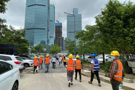 Construction workers walk past office buildings in Shenzhen's Nanshan district, Guangdong province, China June 10, 2022. 