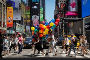 A woman carries a bunch of balloons through Times Square in New York, U.S., June 26, 2019.  