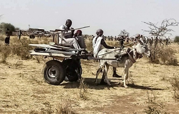 People use a donkey-pulled cart on June 30, 2021, to transport items left behind by the United NationsâAfrican Union Mission in Darfur (UNAMID), after a phased withdrawal from the troubled region