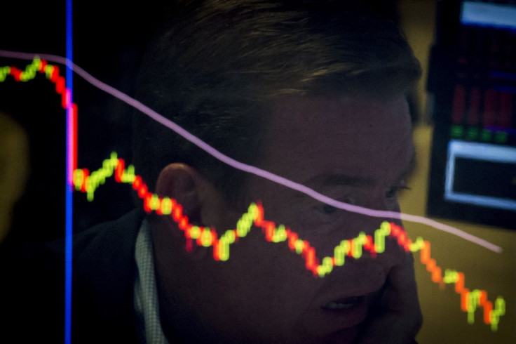 A specialist trader is reflected in a screen at his post on the floor of the New York Stock Exchange, August 21, 2015.  