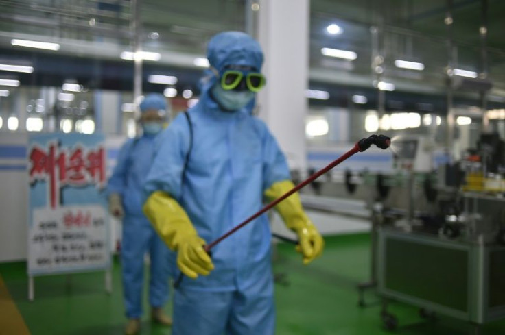 A health official disinfects the workplace floor inside the Ryongaksan soap factory in Pyongyang