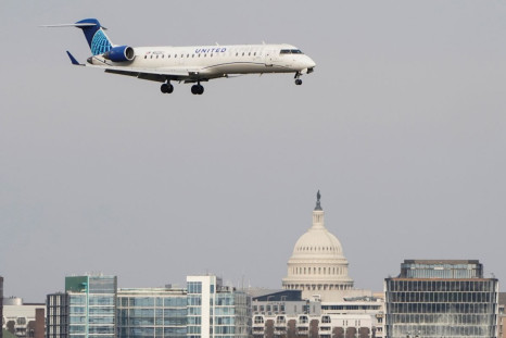 A United Airlines aircraft flies past the U.S. Capitol before landing at Reagan National Airport in Arlington, Virginia, U.S., January 24, 2022.   