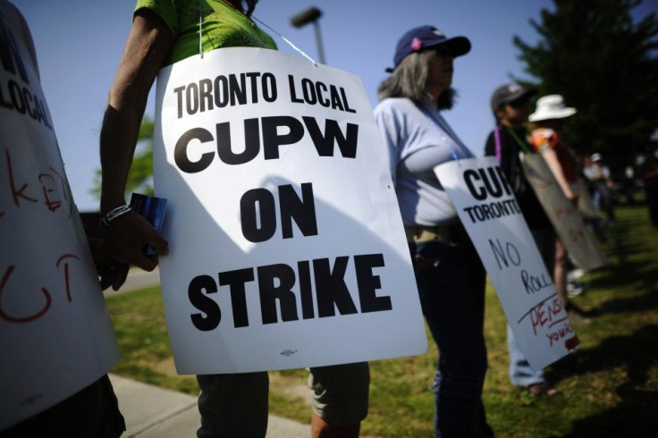 CUPW members stand in front of a Canada Post sorting facility in Toronto