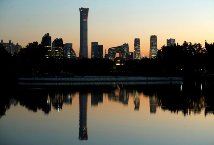 The cityscape of the Beijing Central Business District, or Beijing CBD, is reflected in a pond during sunset, China October 17, 2018.
