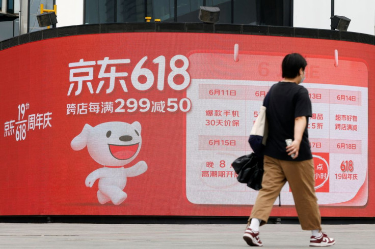 A resident, wearing a face mask following the coronavirus disease (COVID-19) outbreak, walks past a JD.com advertisement for the "618" shopping festival displayed outside a shopping mall in Beijing, China June 14, 2022. 