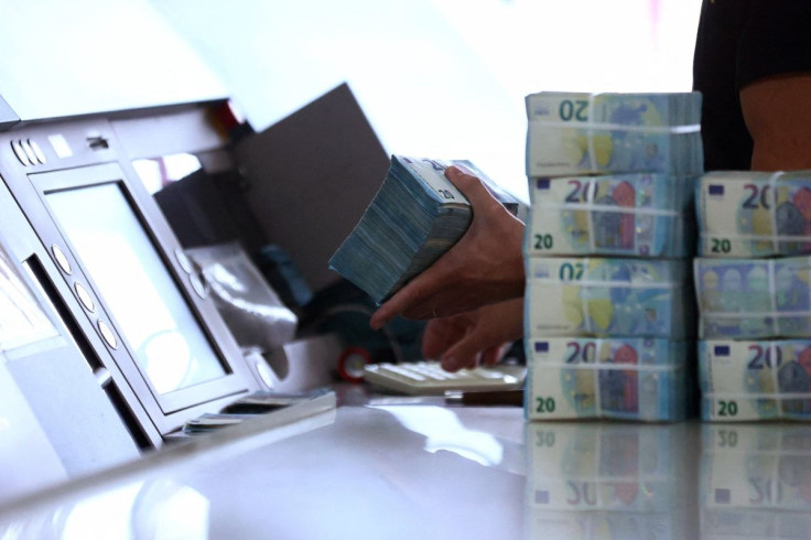 A worker grabs a pack of 20-euro notes at the Bank of Portugal fortified complex in Carregado, Alenquer, Portugal, May 17, 2022. 