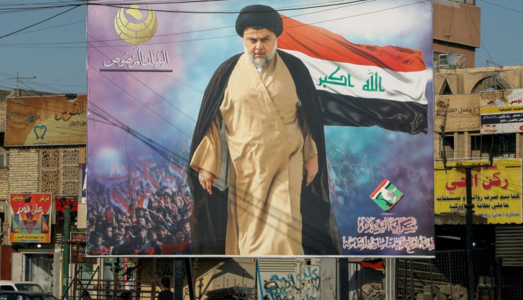 A poster of Iraqi Shi'ite cleric Moqtada al-Sadr in the Sadr City district of Baghdad, Iraq June 21, 2021. The text at the top left of the poster reads 'The Solid Structure'. The text at the bottom right of the poster reads 'Saraya al-Salam, operation com