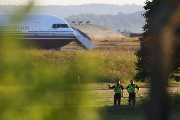 Police officers stand near a plane reported by British media to be first to transport migrants to Rwanda at MOD Boscombe Down base in Wiltshire, Britain, June 14, 2022.