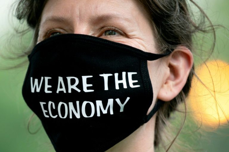 A demonstrator wears a mask reading 'We Are The Economy' in front of the Federal Reserve headquarters where policymakers were deliberating on the next interest rate increase