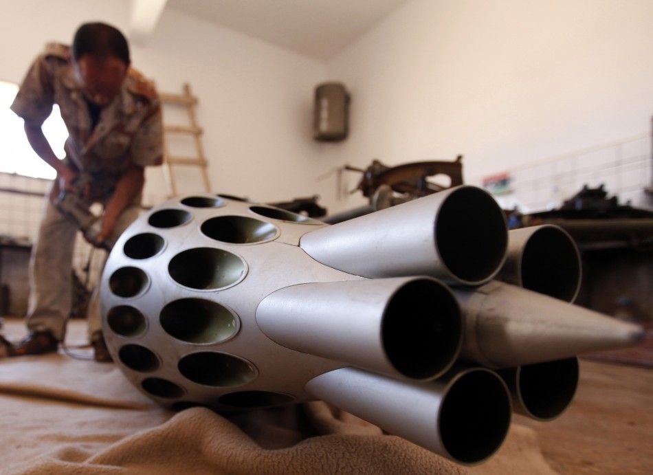 A rebel army officer fixest weapons taken from forces loyal to Libyan leader Muammar Gaddafi at a workshop in Benghazi
