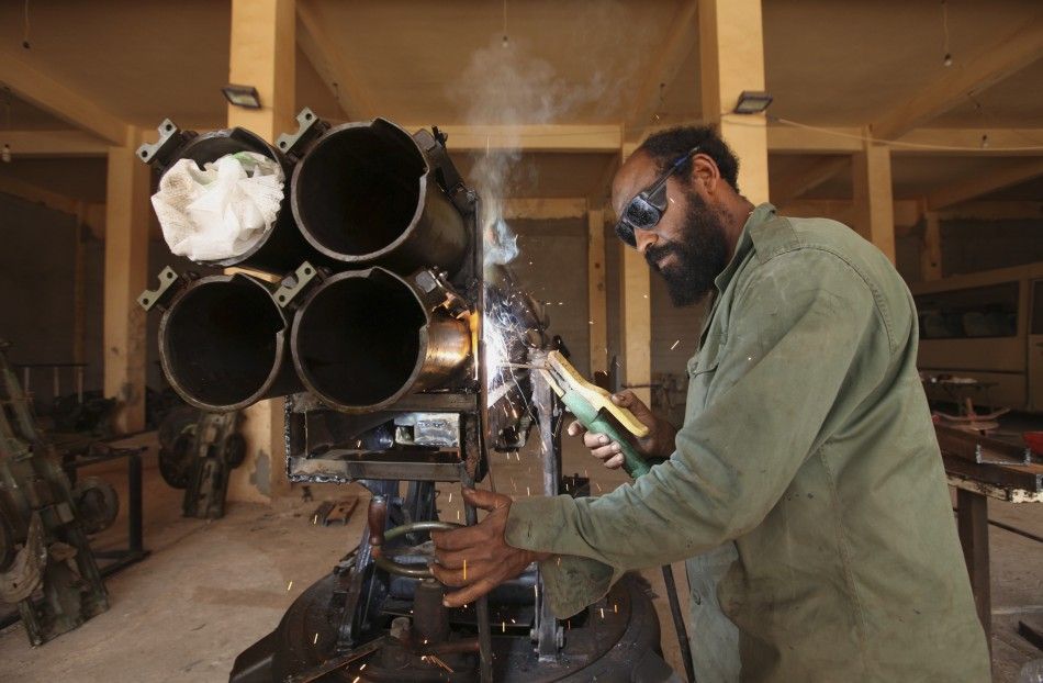 A rebel army officer fixes weapons taken from forces loyal to Libyan leader Muammar Gaddafi at a workshop in Benghazi June 20, 2011.