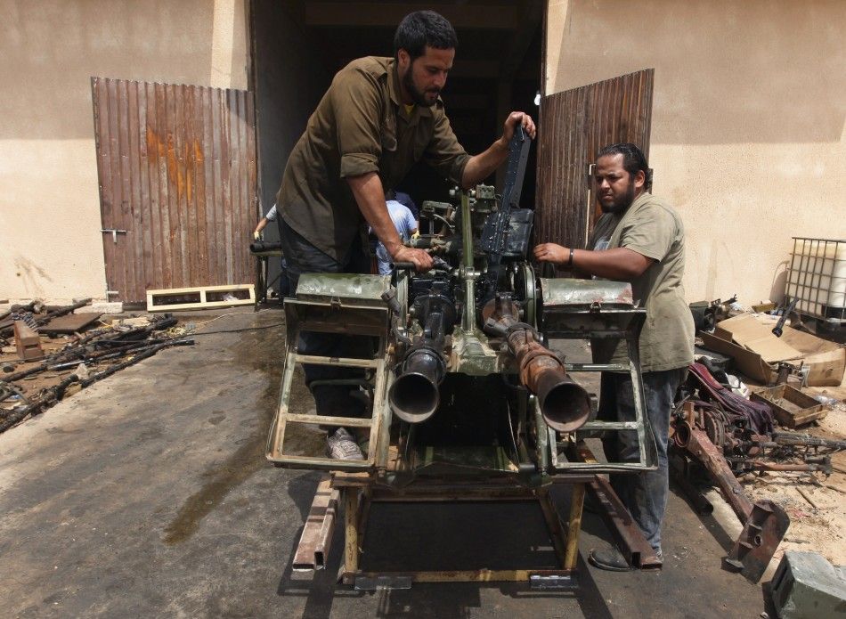 Rebel army officers fix weapons taken from forces loyal to Libyan leader Muammar Gaddafi at a workshop in Benghazi