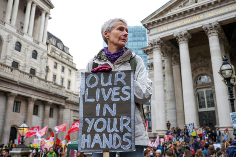 A demonstrator holds a banner during a protest outside the Bank of England, as the UN Climate Change Conference (COP26) takes place, in London, Britain, November 6, 2021. 
