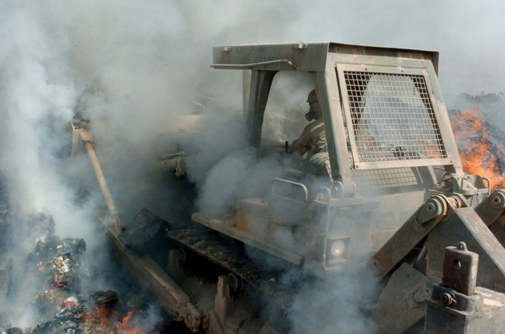 Sgt. Richard Ganske, 84th Combat Engineer Battalion uses a bulldozer to maneuver trash and other burnable items around in the burn pit at the landfill of Logisitics Support Area Anaconda in Balad, Iraq August 24, 2004. Picture taken August 24, 2004. Pfc.