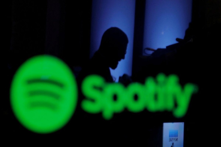 A trader is reflected in a computer screen displaying the Spotify brand at the New York Stock Exchange in New York, U.S., April 3, 2018.  