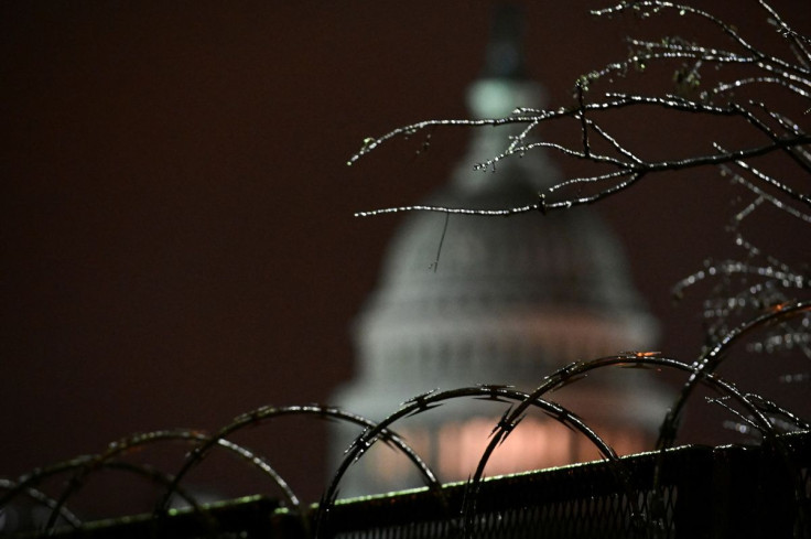 The U.S. Capitol is seen through ice-covered tree branches above barbed wire on a security fence in Washington, U.S. February 13, 2021.
