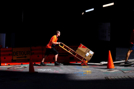 A worker pushes a trolley loaded with goods past a construction site in the central business district (CBD) of Sydney in Australia, March 15, 2018. 