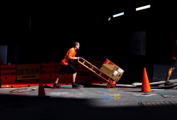 A worker pushes a trolley loaded with goods past a construction site in the central business district (CBD) of Sydney in Australia, March 15, 2018. 