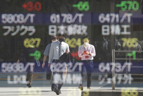 People wearing protective masks, amid the coronavirus disease (COVID-19) outbreak, are reflected on an electronic board displaying Japan's stock prices outside a brokerage in Tokyo, Japan, October 5, 2021. 