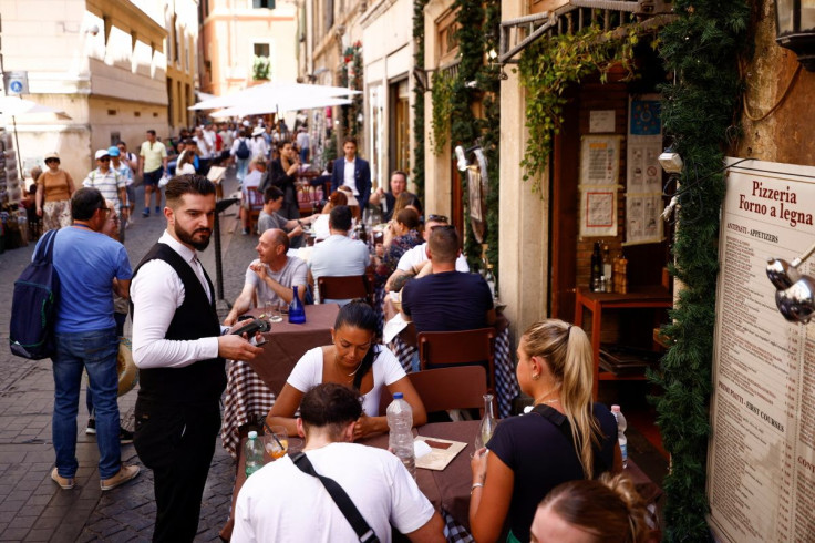 A waiter holds a point-of-sale (POS) device at a restaurant near the Pantheon, on the day the European Central Bank's rate-setting Governing Council holds an unscheduled meeting to discuss the recent sell-off in government bond market, in Rome, Italy, Jun