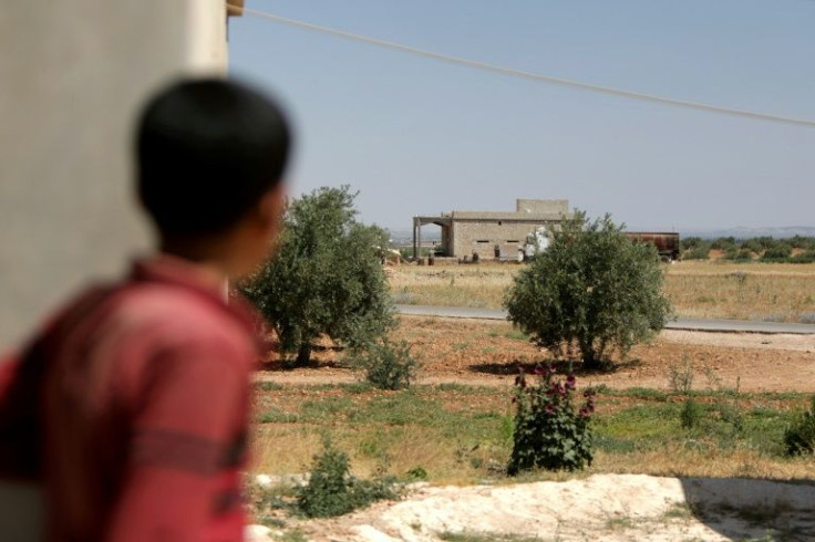 A boy looks at a building where US coalition forces conducted an overnight airborne operation to capture an Islamic State group bombmaker, in the village of Hmeirah in the north of Syria's Aleppo province on June 16, 2022